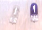 1999 Ford Taurus - Two small light bulbs, one clear and one tinted purple, are shown against a light-colored background.