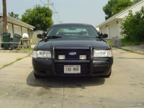 2000 Ford Crown Victoria - Front view of a black 2000 Ford Crown Victoria, equipped with a push bar and a Wisconsin license plate.