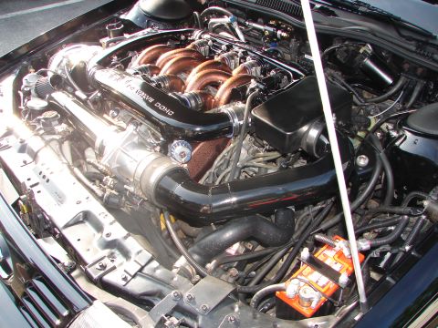 1992 Ford Taurus - Close-up of a modified engine bay, showing custom intake and exhaust components.