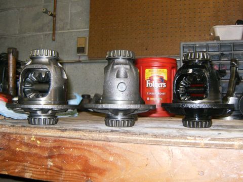 2000 Ford E350 - Three differential assemblies are displayed on a wooden surface, with a red coffee can in the background.