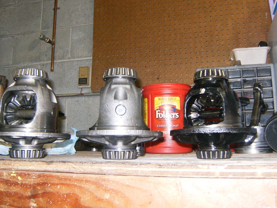 Three differential gears on a wooden shelf, with a Folgers coffee can and tool organizer in the background