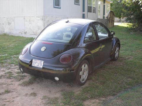 1999 Volkswagen Beetle - Rear view of a black Volkswagen Beetle with a license plate visible.