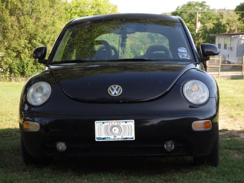 1999 Volkswagen Beetle - A black Volkswagen Beetle is shown from the front, parked outdoors on a grassy area.