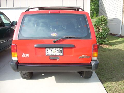 2005 Ford F-250 - Red Jeep Cherokee parked in a driveway.