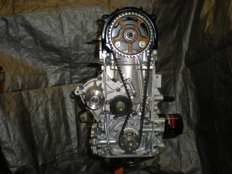 2009 Suzuki Samurai - Engine assembly with timing belt and pulleys, set against a dark tarp background.