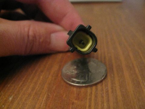 1994 Ford Probe - A close-up shows an electrical connector with a yellow insert, placed next to a U.S. quarter for scale.