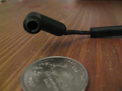 1994 Ford Probe - A spark plug wire boot and cable are shown next to a quarter for scale.