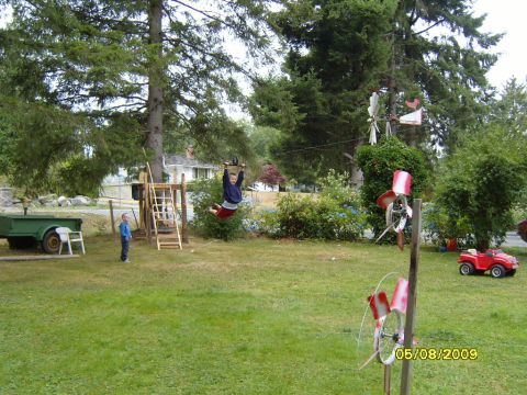 1989 Ford Bronco - A backyard scene with children enjoying a zipline and a toy car, with a trailer in the background.