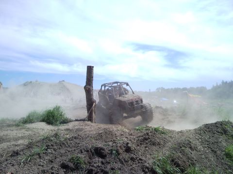 1979 Ford Bronco - An off-road buggy navigates a challenging dirt course, kicking up dust as it goes.