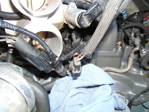 1988 Ford Bronco - Close-up view of engine components, including wiring and a throttle body.