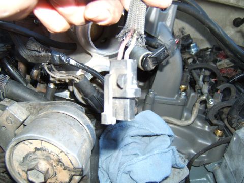 1988 Ford Bronco - Close-up of a vehicle's engine bay, focusing on a disconnected electrical connector with damaged wiring.