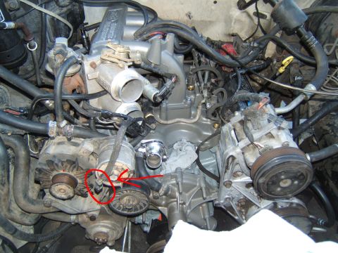 1988 Ford Bronco - Close-up view of a V8 engine, focusing on the alternator, AC compressor, and associated belts and pulleys.