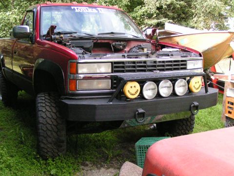 1984 Chevrolet Blazer - This red pickup truck has an open hood and an aftermarket bumper with auxiliary lights.