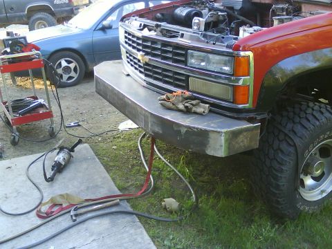 1984 Chevrolet Blazer - A red truck with a custom metal bumper and its hood open, parked next to a blue sedan.