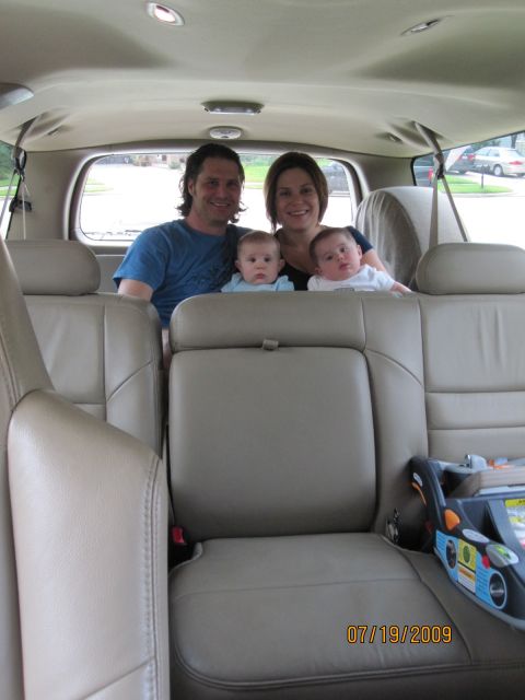 2005 Ford Excursion - A family of four, including two infants, is pictured inside the spacious interior of an SUV.