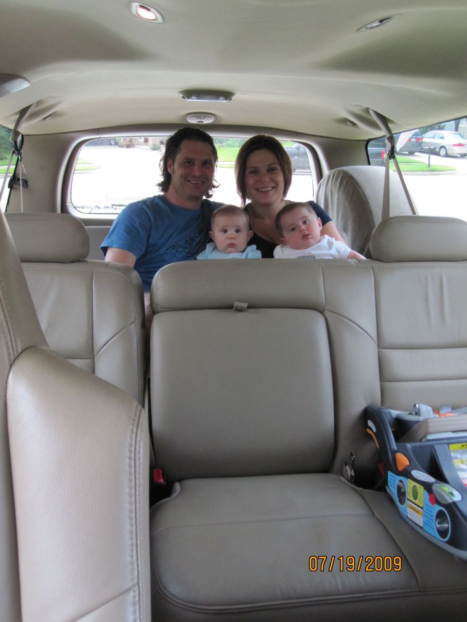 Family with two babies in the back seat of an SUV