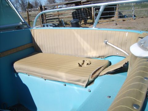 1988 Chevrolet Suburban - The interior of a boat shows worn tan seating and a blue hull, with a Supermotors.net logo in the corner.