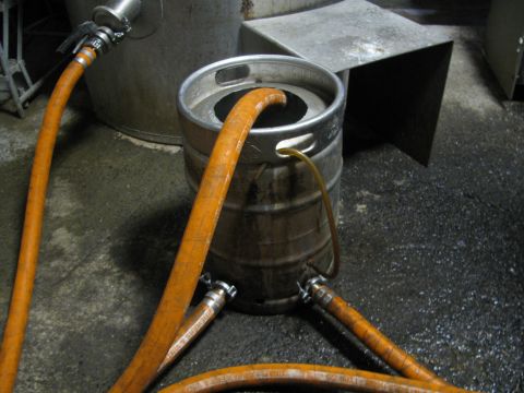 1985 Ford LTD Crown Victoria - A beer keg is connected to hoses, likely for transferring liquid during a brewing process.