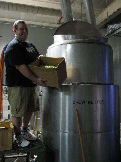 1985 Ford LTD Crown Victoria - A man adds hops to a large brew kettle at a brewery.