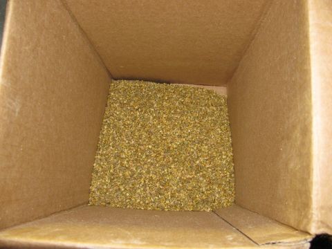 1985 Ford LTD Crown Victoria - The interior of a cardboard box is filled with a granular substance.