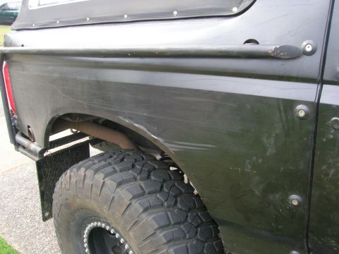1996 Ford Bronco - Close-up of the rear wheel well and side panel of a 1996 Ford Bronco.