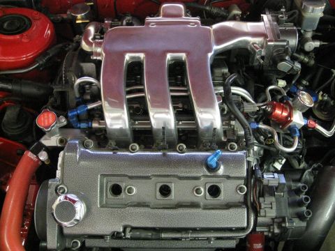 1994 Ford Probe - Close-up of a modified engine bay, showing polished intake runners and various engine components.
