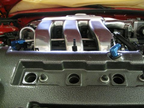 1994 Ford Probe - Close-up view of an engine's intake manifold and valve cover, showing custom modifications.