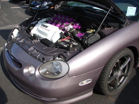 1992 Ford Taurus - Customized engine bay of a 1999 Ford Taurus, a V8 32-valve engine with purple accents and a prominent intake manifold cover.