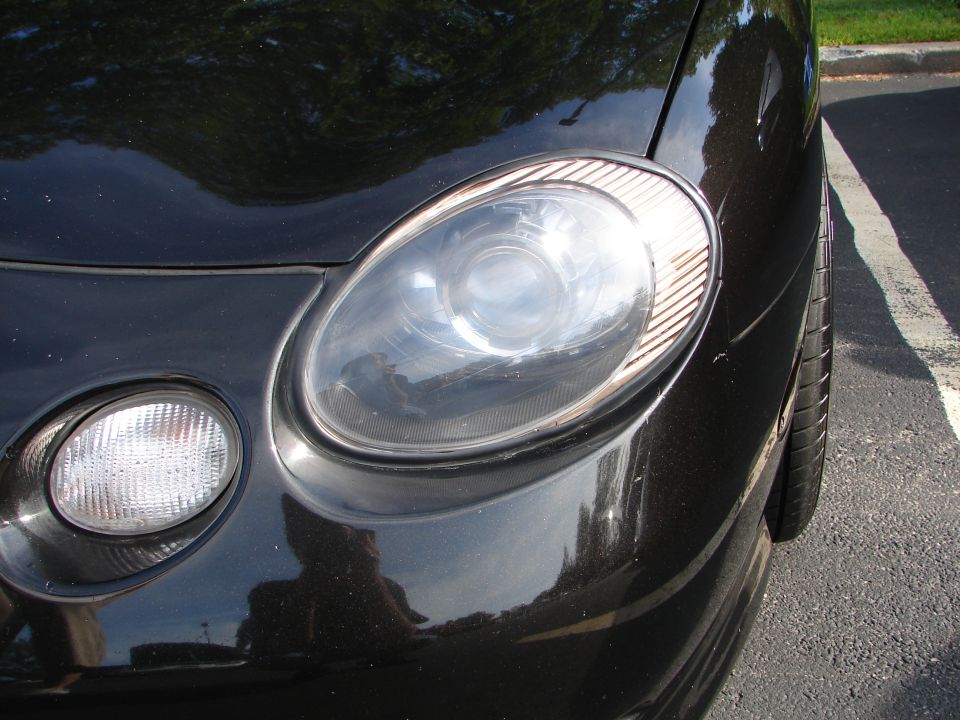 Black car headlight assembly with fog light below, close-up front view