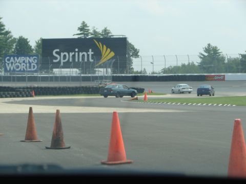 1992 Ford Taurus - Multiple vehicles navigate a race track with a large Sprint billboard in the background.