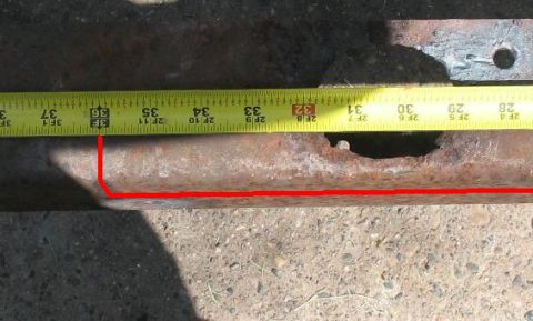 1978 Ford Bronco - Measuring a rusted metal part with a tape measure.