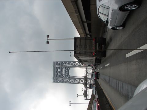1992 Ford Taurus - A view of traffic on a bridge, with a prominent suspension tower in the background and a silver car in the foreground.