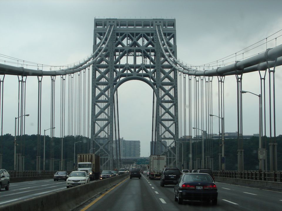 Traffic on a bridge with a large suspension tower overhead