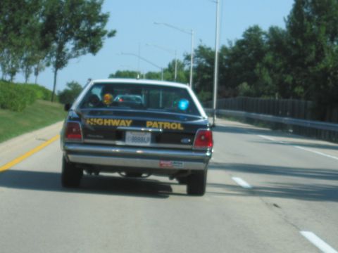 1991 Ford Crown Victoria - Rear view of a 1991 Ford Crown Victoria police car with 'HIGHWAY PATROL' text on the trunk.