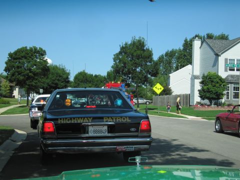 1991 Ford Crown Victoria - A black 1991 Ford Crown Victoria, marked as "HIGHWAY PATROL", is seen from behind in a residential area.