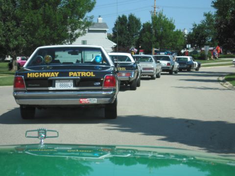 1991 Ford Crown Victoria - Several Highway Patrol cars are lined up on a street on a sunny day.