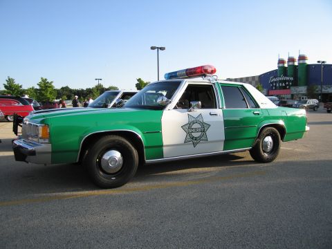 1991 Ford Crown Victoria - This 1991 Ford Crown Victoria police car features a distinctive green and white livery with a sheriff's star emblem on the door.