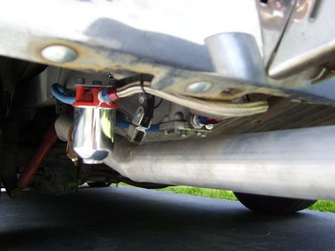 1972 Ford Ranchero - Low underbody shot along the frame rail of a white vehicle showing a polished canister fuel filter with a red anodized head, braided stainl…