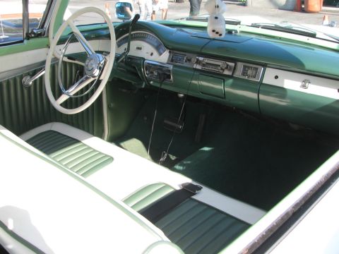 1990 Ford Bronco - interior of a classic car shows a green dashboard, white steering wheel and green-and-white ribbed bench seats.