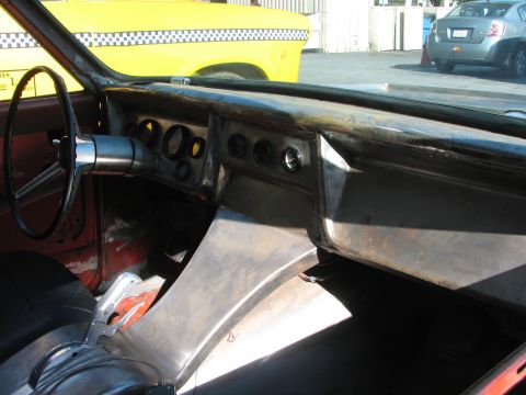 1990 Ford Bronco - in-progress custom car interior showing a bare-metal dashboard, exposed gauges, steering wheel and red door panels.