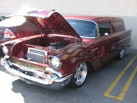 1990 Ford Bronco - maroon 1957 Chevrolet sedan delivery wagon with flame paint and chrome wheels sits with its hood open showing the engine.