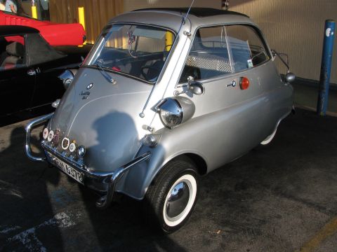1990 Ford Bronco - silver BMW Isetta bubble car with its single front-opening door and whitewall tires parked in a covered space.