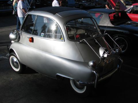 1990 Ford Bronco - rear three-quarter view of a silver BMW Isetta microcar fitted with a rear luggage rack and whitewall tires.