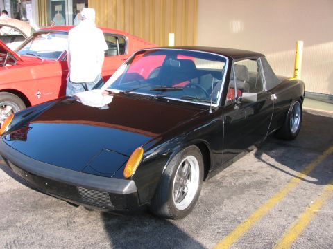 1990 Ford Bronco - black Porsche 914 mid-engine targa with pop-up headlights and alloy wheels parked in a covered lot.