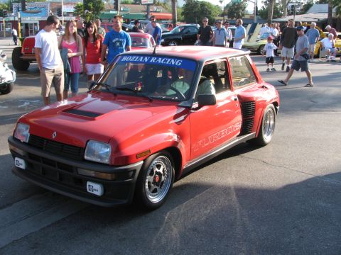 1990 Ford Bronco - red Renault 5 Turbo with flared rear fenders, Turbo side graphics and a Bozian Racing windshield banner at a car show.