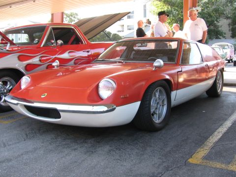 1990 Ford Bronco - red Lotus Europa sports car with alloy wheels and green Lotus nose badge shown from the front and side.