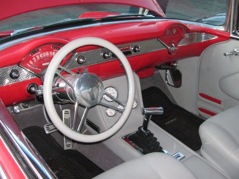 1990 Ford Bronco - custom red-and-white 1950s Chevrolet interior with a white banjo steering wheel, chrome shifter and engine-turned dash.
