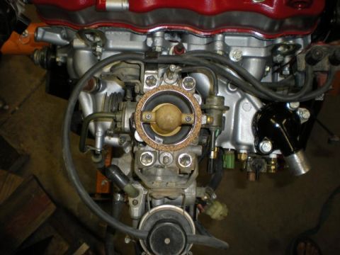 Suzuki Samurai - Close-up view of an engine's carburetor and intake manifold assembly.