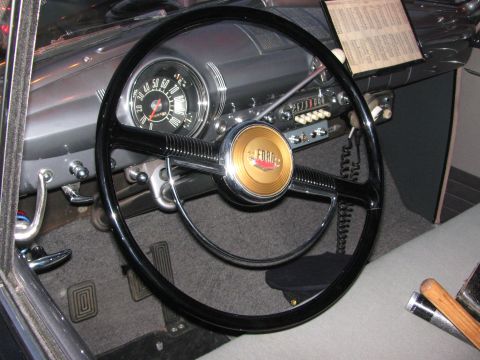 1990 Ford Bronco - interior of a vintage car showing a large black steering wheel, round gauge cluster and Ford horn button.
