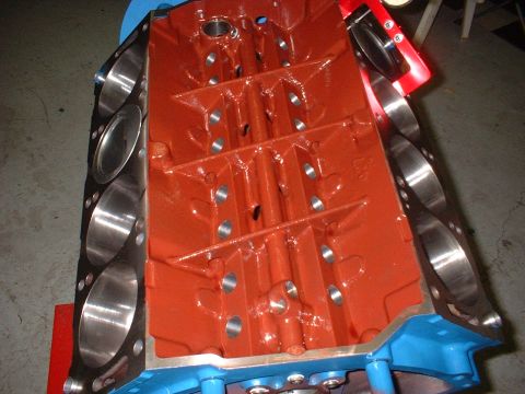 1968 Ford Galaxie - An engine block, painted orange and blue, is shown from a top-down perspective, revealing its internal components and cylinder bores.